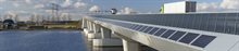 Brug in de ochtendzon met zonnecellen, een elektriciteitsmast in de achtergrond